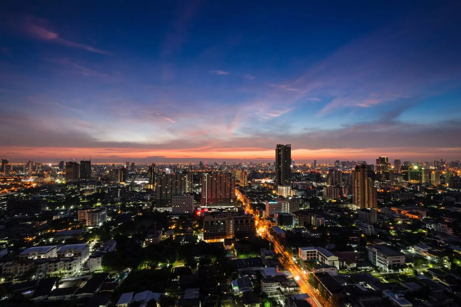 a picture of the city at night with a blue and pink skyline