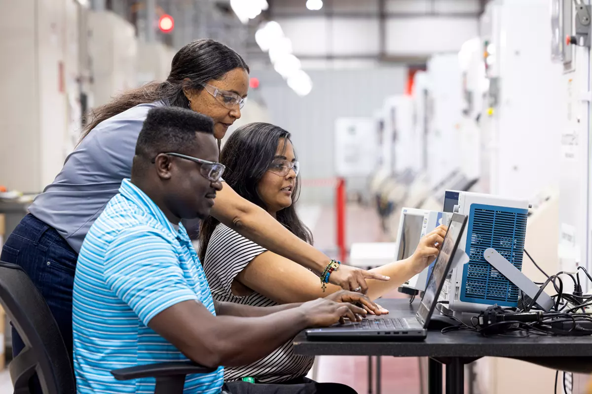 People collaborating on a laptop.